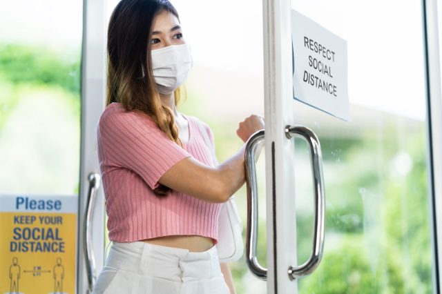 woman wear face mask entering shop or restaurant