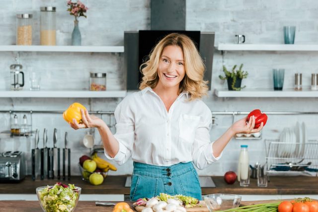 woman cooking with bell peppers to live a longer life