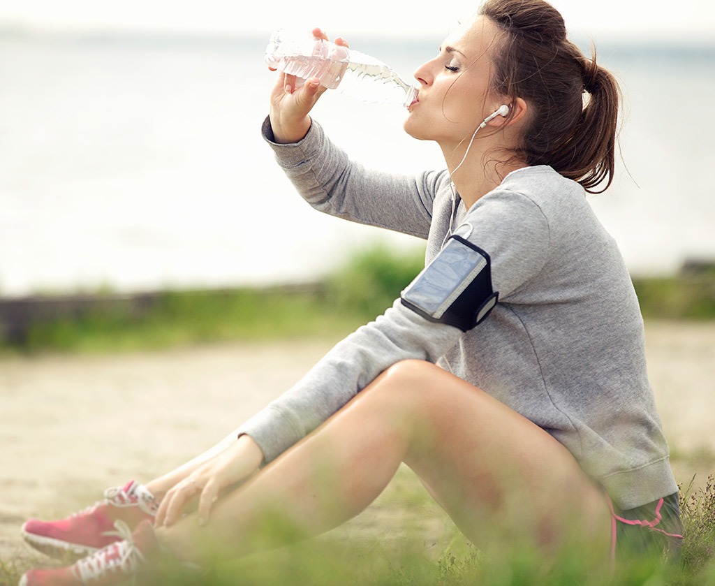 Woman drinking water after run