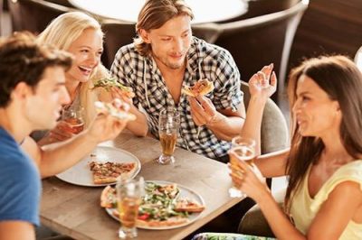 Friends eating pizza in restaurant