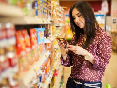 Woman reading food label in supermarket