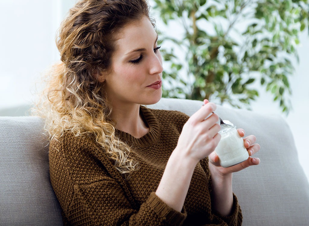 Woman eating yogurt couch.jpg