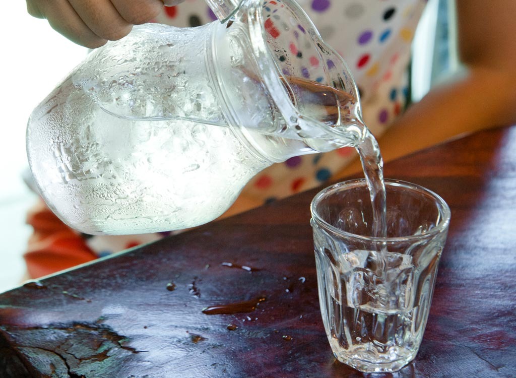 pouring glass of water from a pitcher