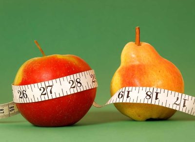 Apple and pear with measuring tape