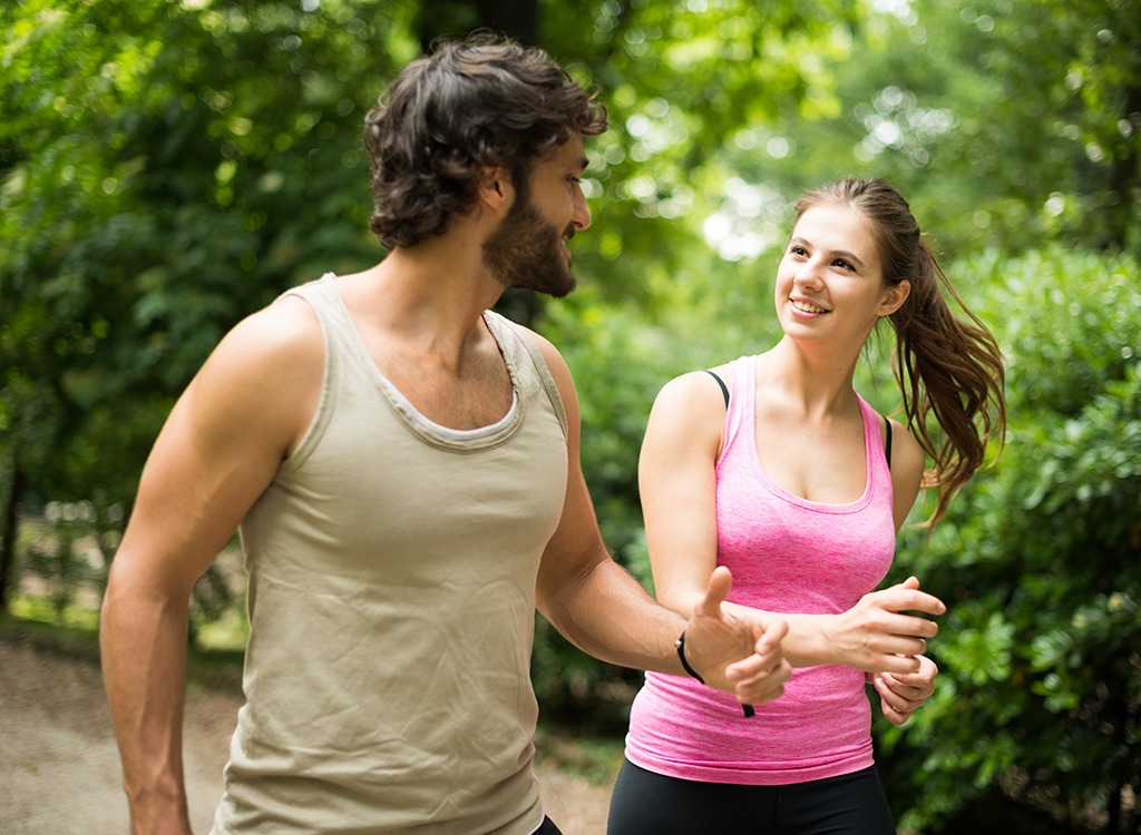 man and woman walking together in park