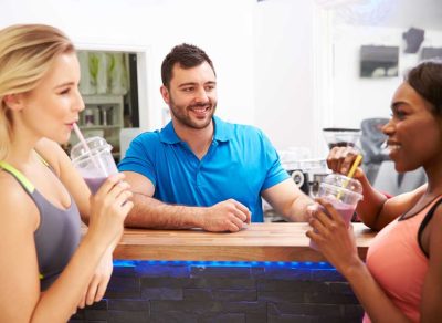 Women drinking protein shakes at gym