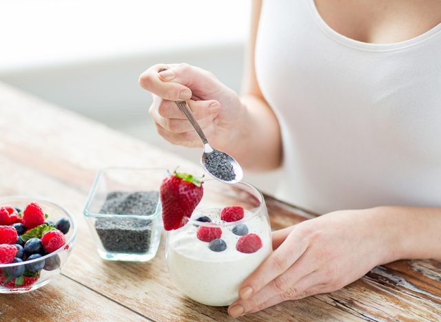 woman eating yogurt with chia seeds and fruits