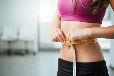Woman measuring slim waist