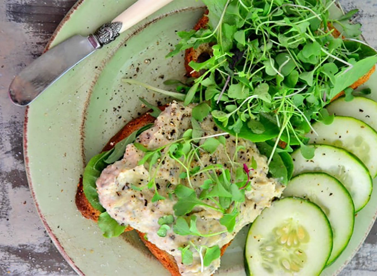 vegan white bean and dill spread on toast with sprouts and cucumber slices