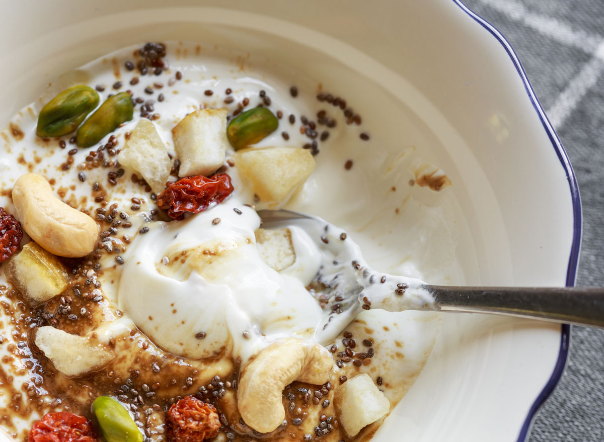 Bowl of yogurt with chia seeds cashew and pistachio nuts and fruit