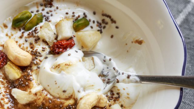 Bowl of yogurt with chia seeds cashew and pistachio nuts and fruit