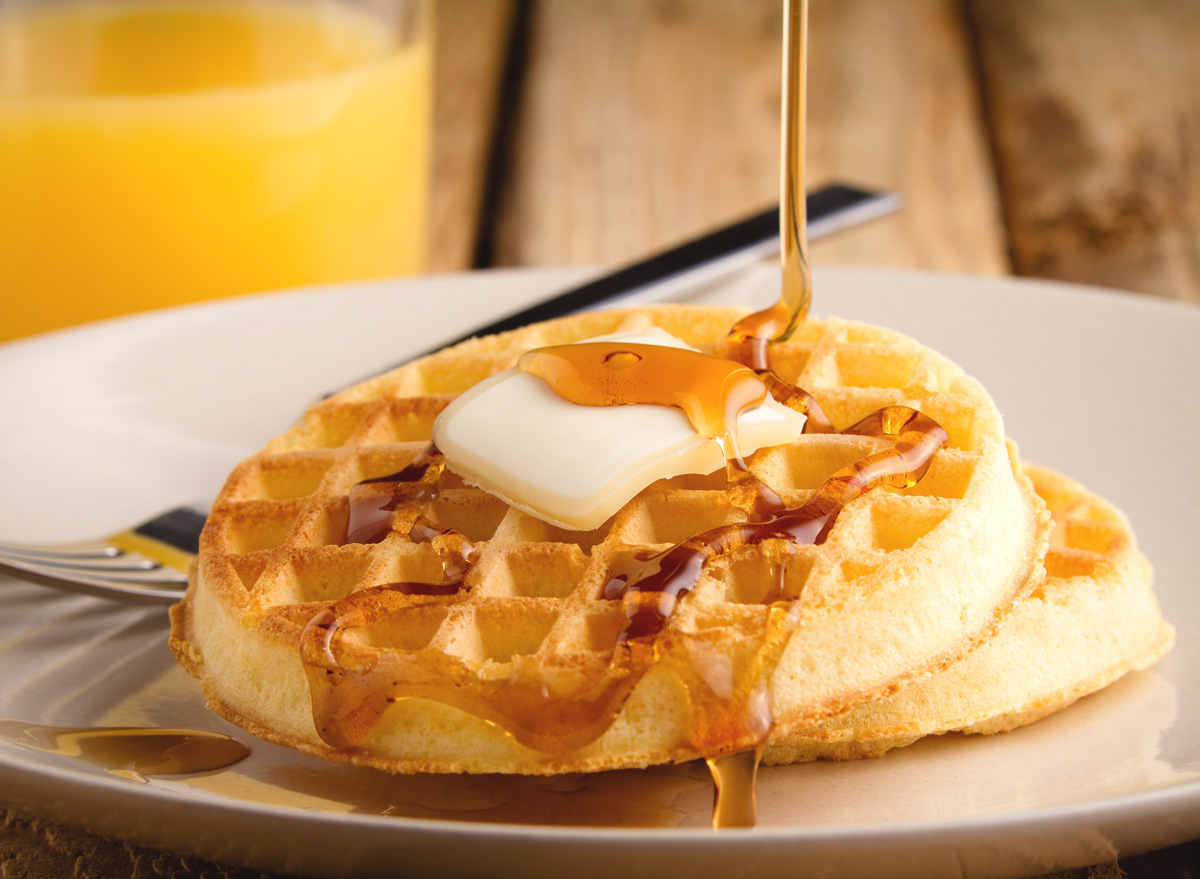 Toaster waffles with syrup butter and orange juice breakfast