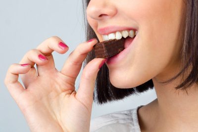 woman taking a bite of chocolate and enjoying her dessert