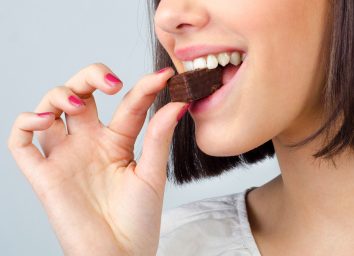 woman taking a bite of chocolate and enjoying her dessert