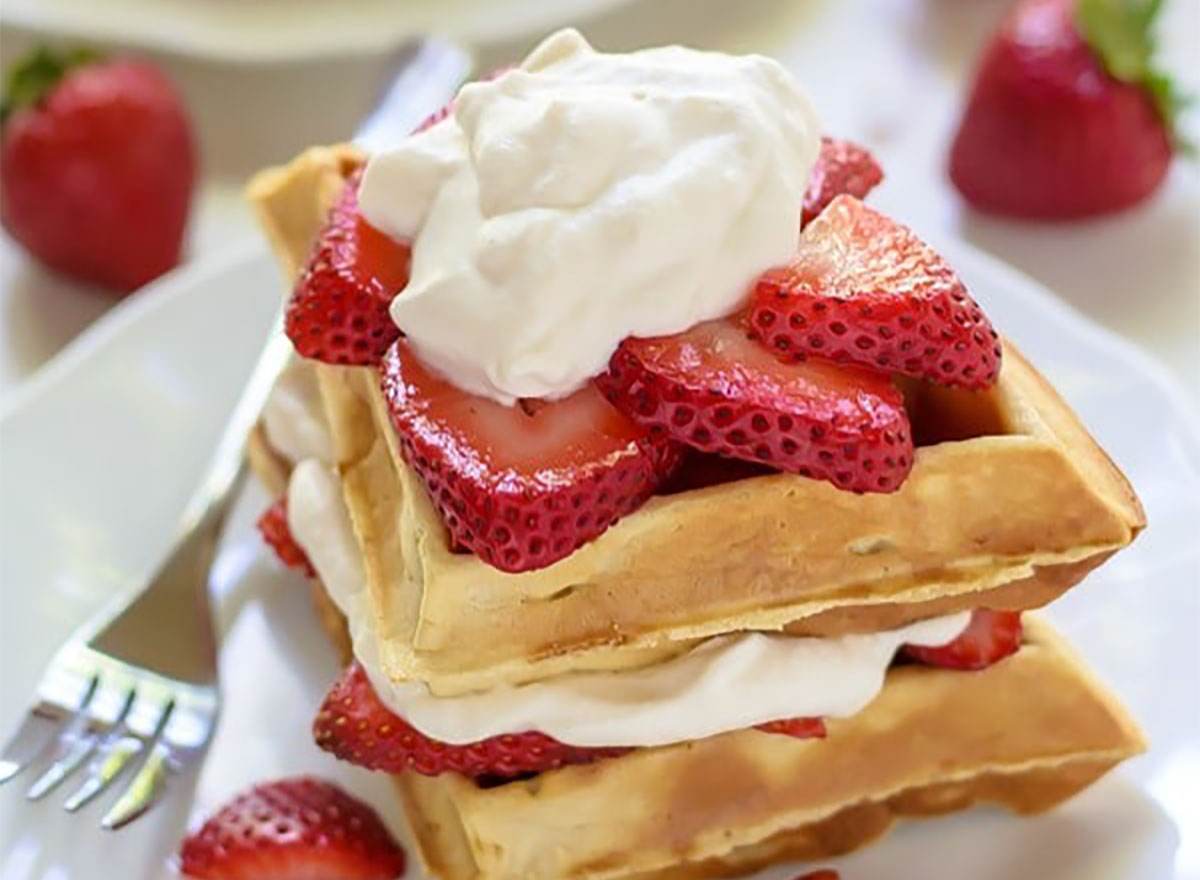 stack of strawberry waffles with whipped cream