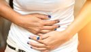 Woman holding bloated stomach belly