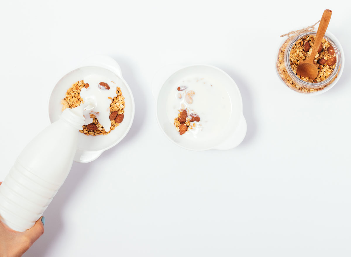 almond milk poured in cereal on white counter