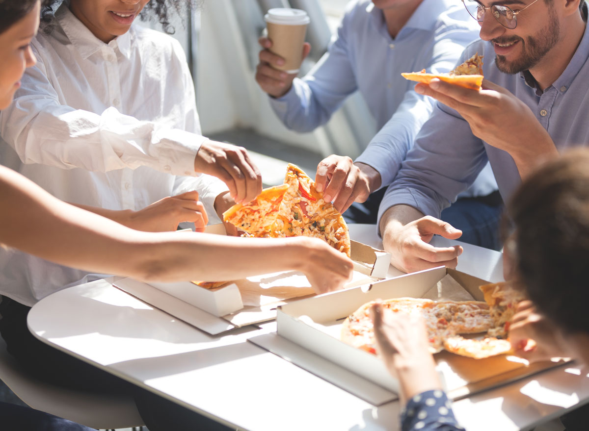 Coworkers quickly grabbing slices of pizza at work - always hungry reasons