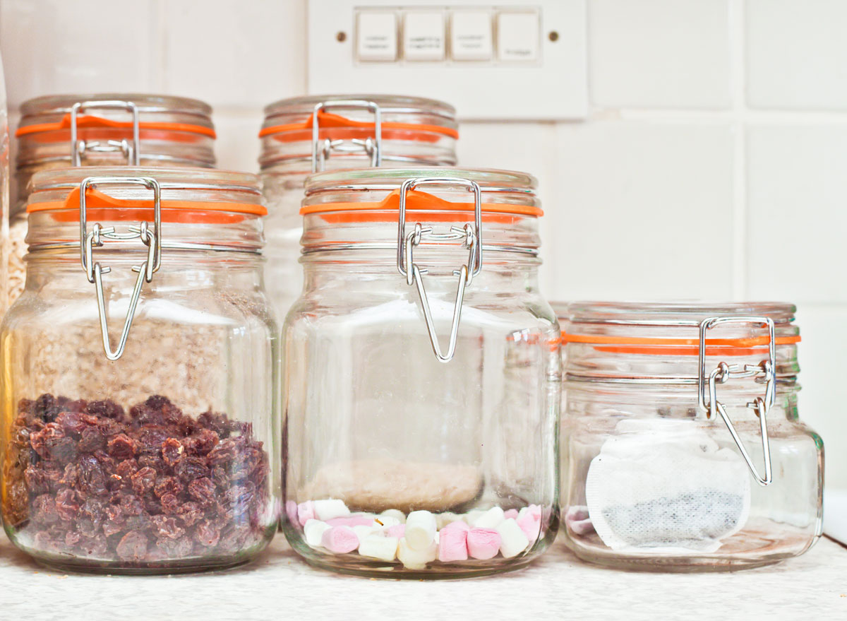Candy and snacks visible in glass transparent containers on kitchen counter
