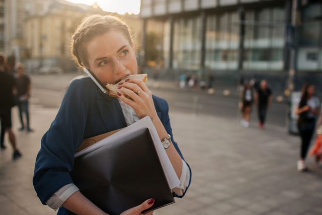 Woman eating while talking walking on the go