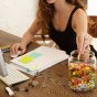 Woman eating candy from glass jar at work