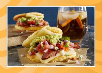 two breakfast sandwiches and a drink on a table