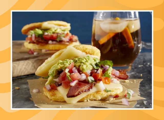two breakfast sandwiches and a drink on a table