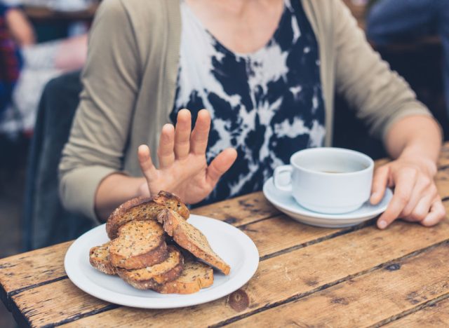 Woman refusing to eat bread, concept of wellness myths circulating the internet