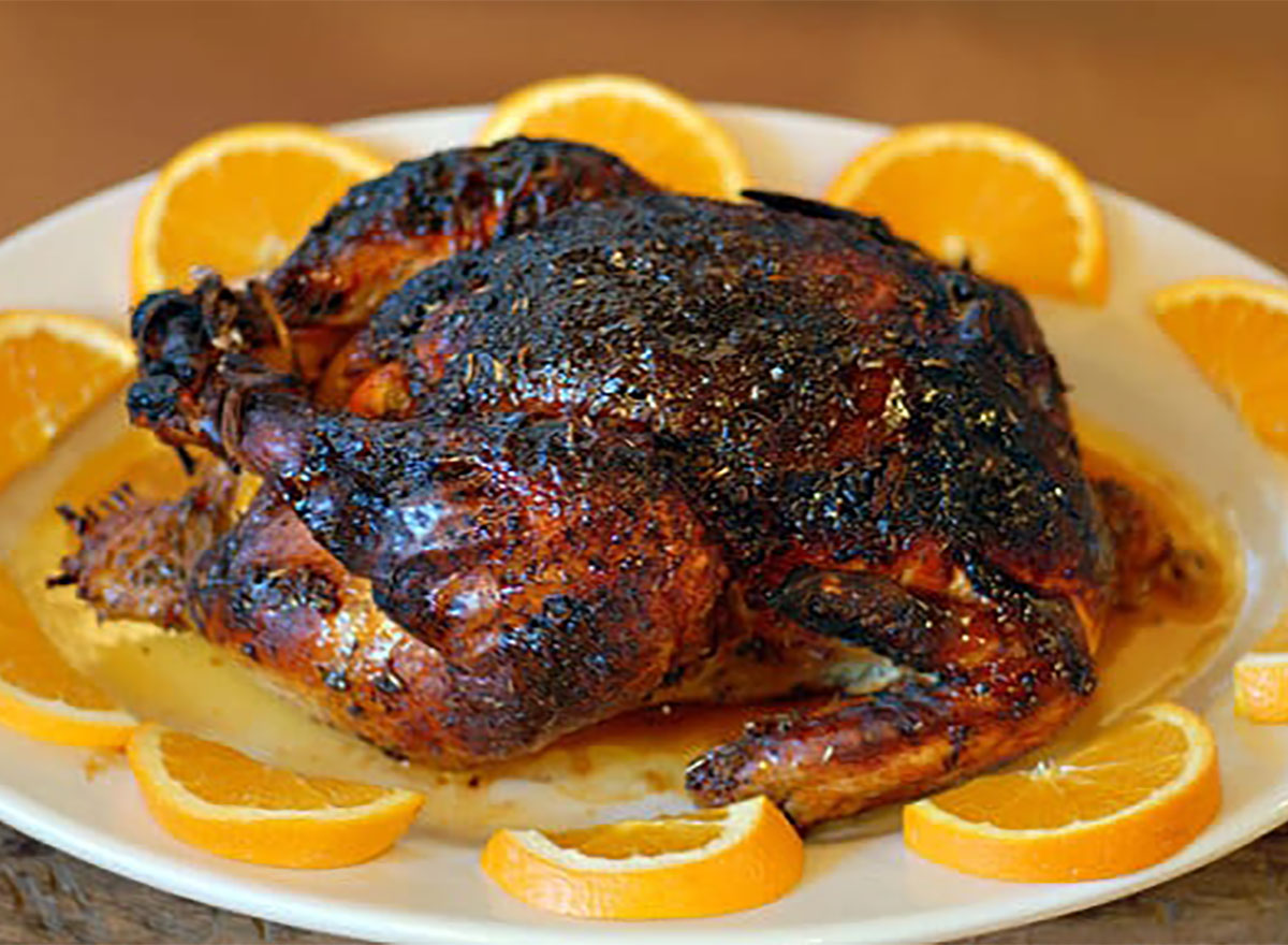 whole roasted chicken on a bed of orange slices