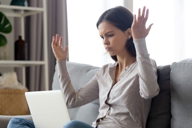 Annoyed woman cranky on laptop