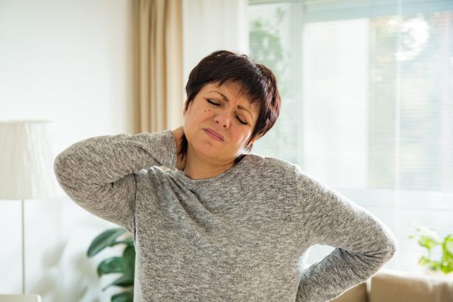 Woman holding sore neck