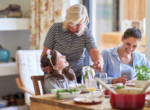 Women from different generations young middle aged and mature eating at a dinner table together