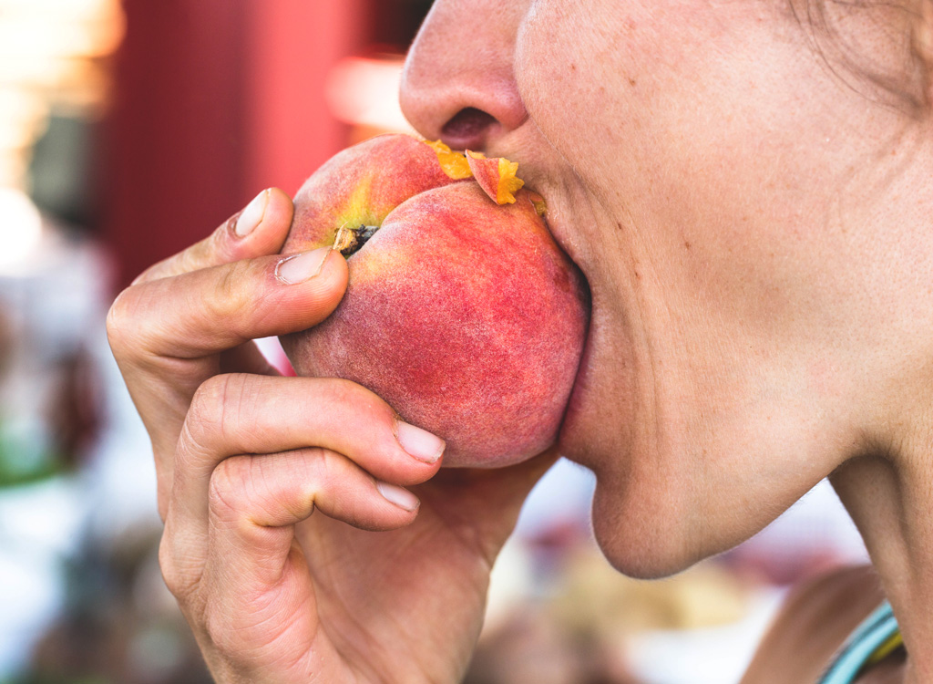 Woman eating peach