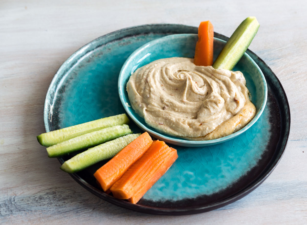 https://www.eatthis.com/wp-content/uploads/sites/4/2017/07/hummus-carrots-cucumber-healthy-snack.jpg