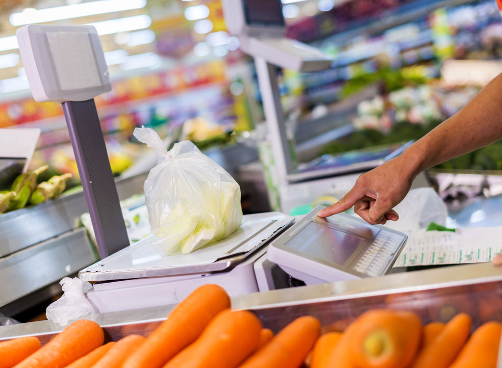 Grocer weighing food at supermarket