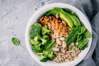 Healthy quinoa lunch bowl with chicken as protein avocado as fat and vegetables broccoli and spinach and beans