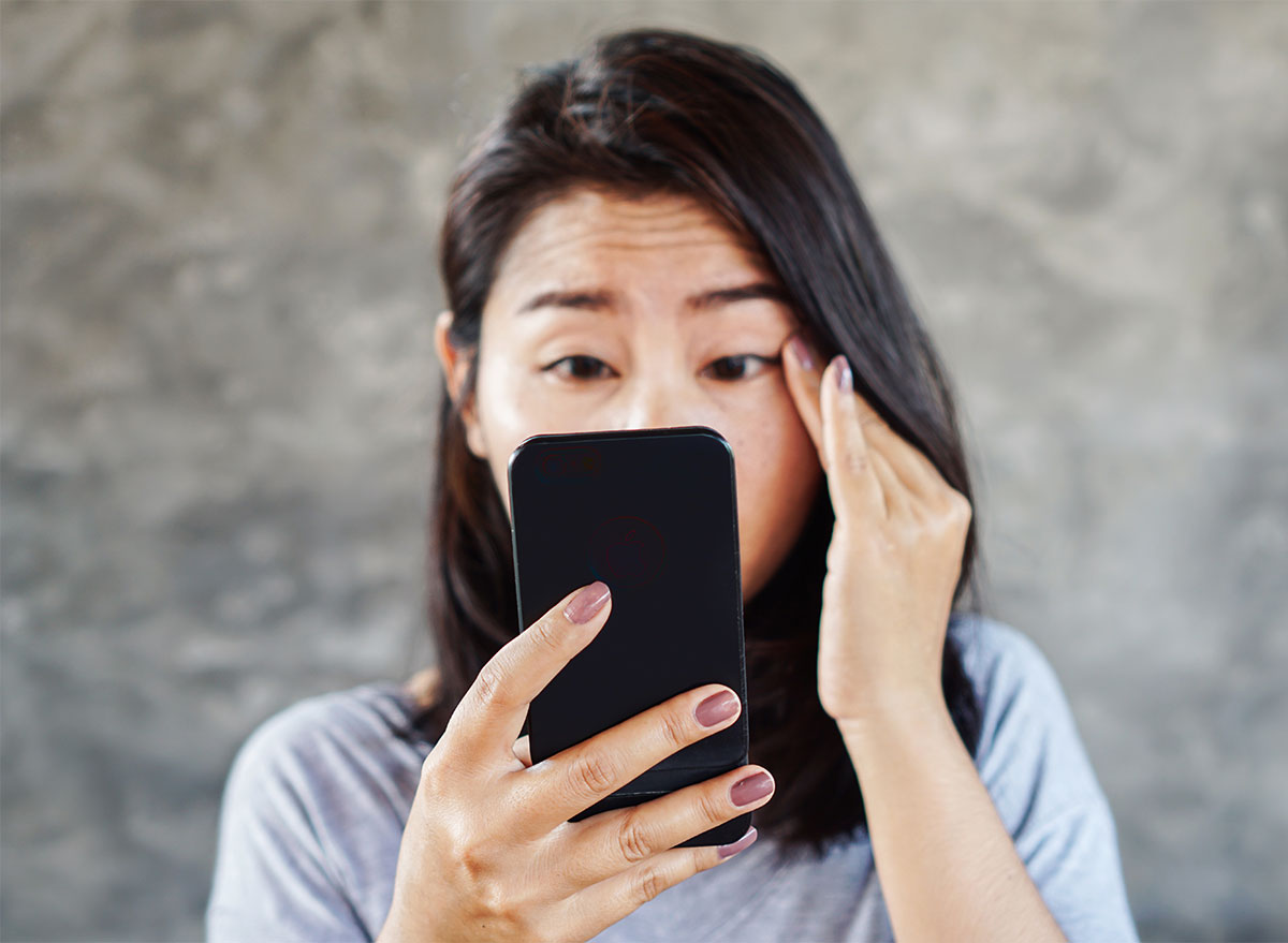 woman squinting at phone