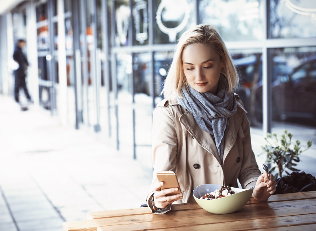 woman texting eating