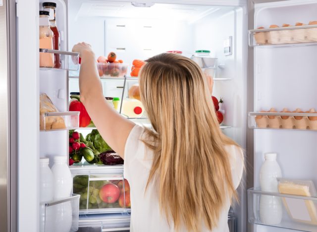 A hungry woman looking for food in the refrigerator