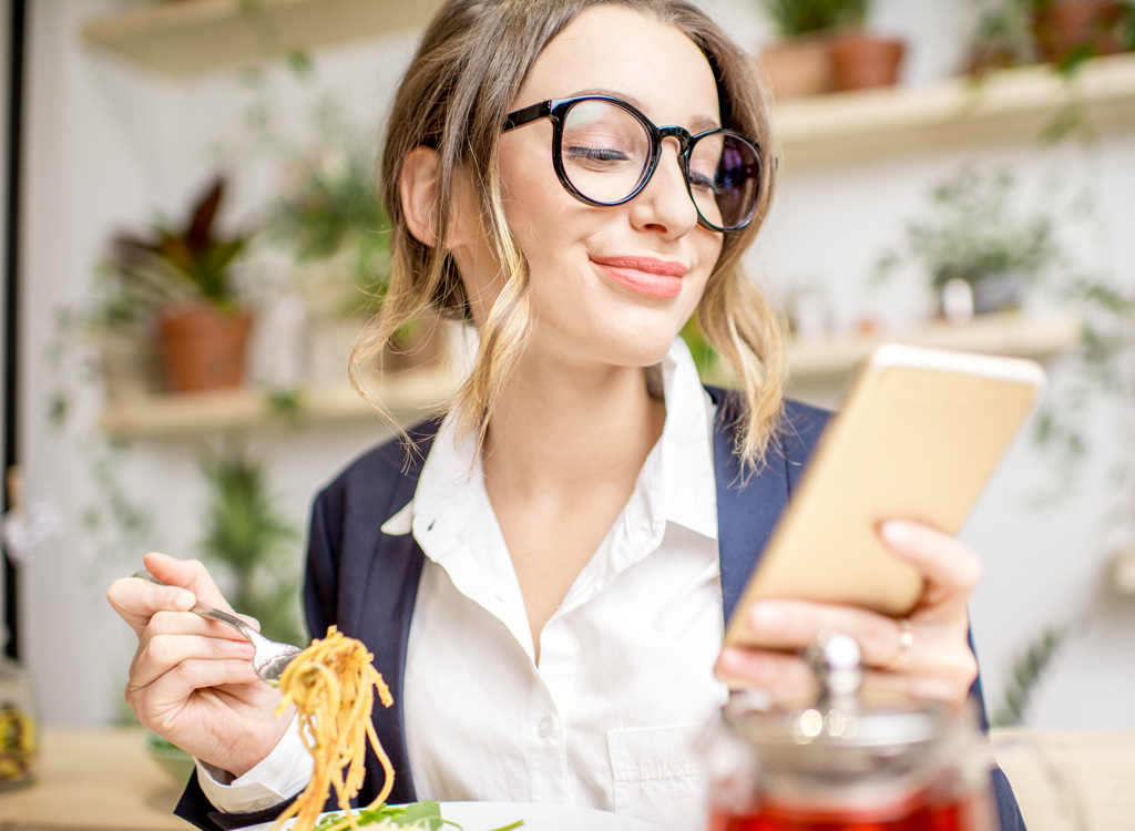 Woman eating with phone