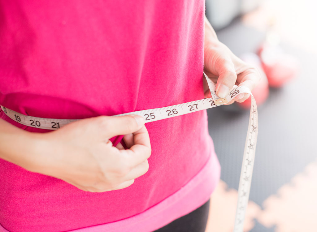 Woman measuring waistline