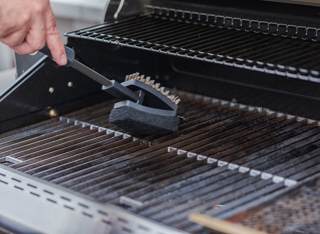 Cleaning grill with a brush