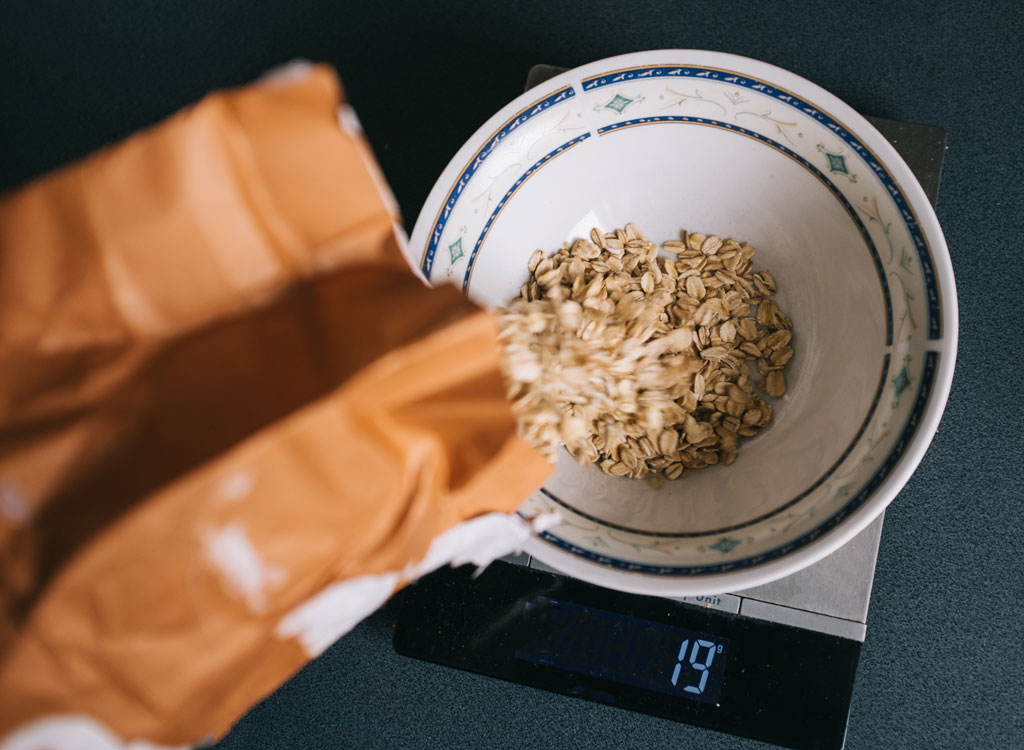 Pouring oats into bowl to measure portion on scale