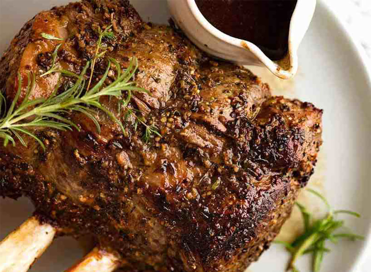 standing rib roast on plate with rosemary