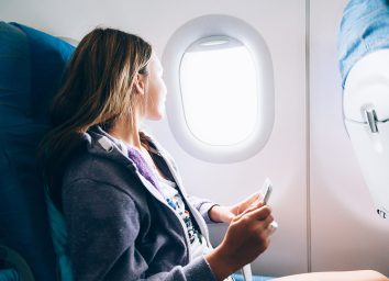 https://www.eatthis.com/wp-content/uploads/sites/4/2018/05/woman-sitting-in-airplane-shutterstock.jpg?quality=82&strip=all&w=354&h=256&crop=1