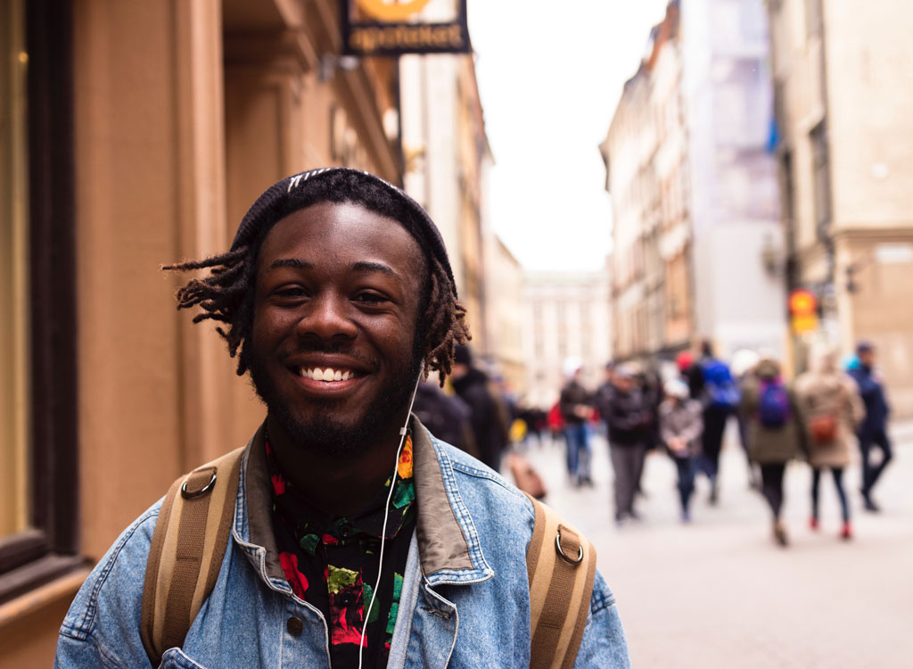 man smiling headphones in outside city