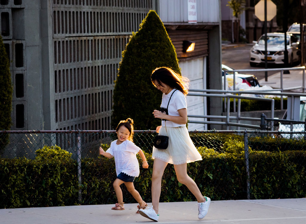 Woman and daughter running uphill