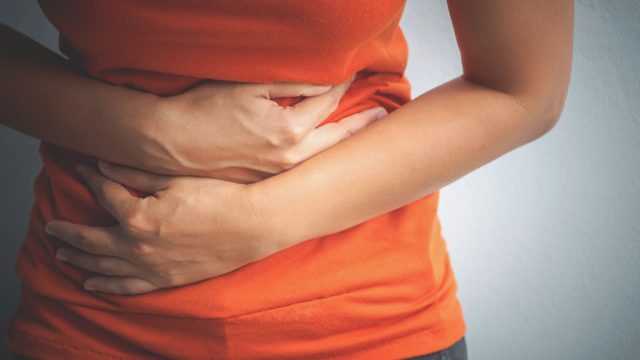 Woman holding stomach cramps digestive problems