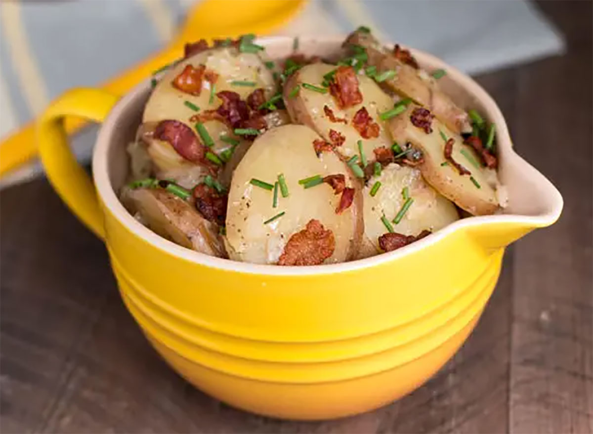 hot german potato salad in yellow mixing bowl