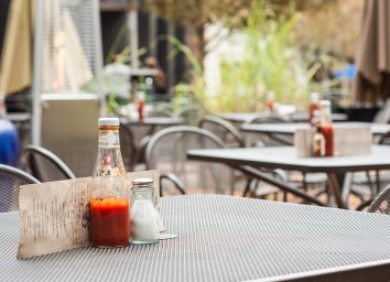Ketchup glass bottle on table at restaurant